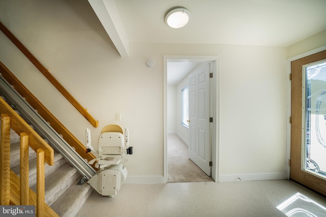 carpeted entryway featuring vaulted ceiling with beams