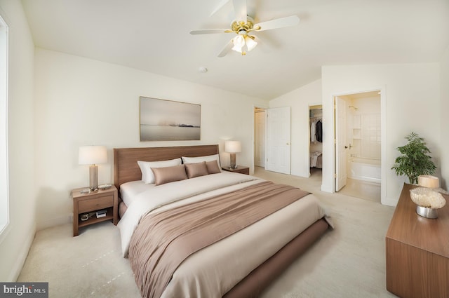 bedroom featuring a spacious closet, connected bathroom, a closet, lofted ceiling, and ceiling fan