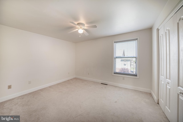 unfurnished room featuring visible vents, a ceiling fan, baseboards, and light carpet