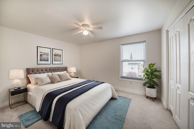 bedroom featuring a ceiling fan, light colored carpet, and baseboards