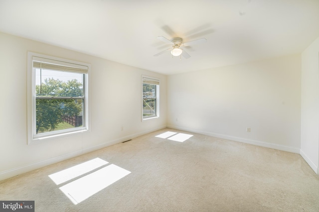 empty room featuring ceiling fan, baseboards, and carpet