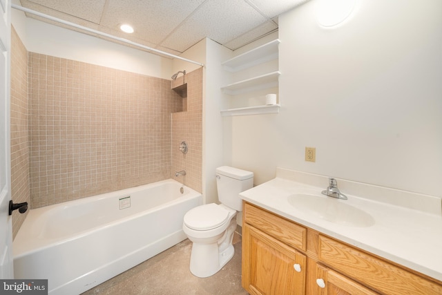 bathroom with bathtub / shower combination, toilet, vanity, and a drop ceiling