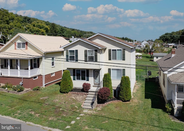 view of front facade with metal roof and a front lawn