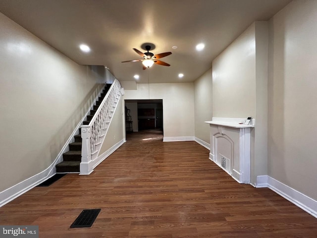 interior space with ceiling fan, dark hardwood / wood-style floors, and a fireplace