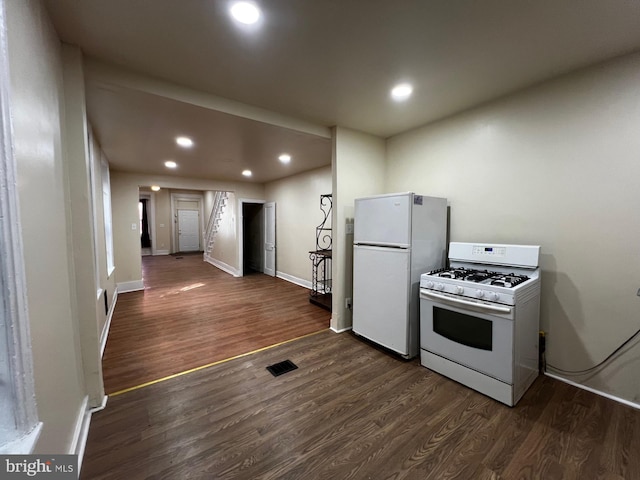 kitchen with white appliances and dark hardwood / wood-style flooring