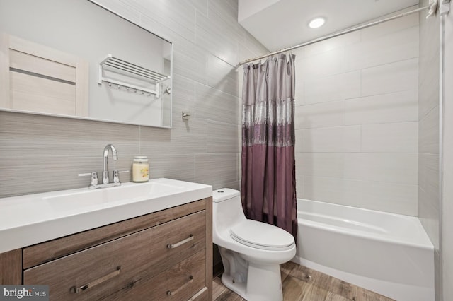 full bathroom featuring tile walls, hardwood / wood-style floors, shower / bath combo with shower curtain, and toilet