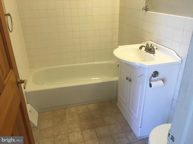 full bathroom featuring vanity, toilet, tile walls, and bathing tub / shower combination