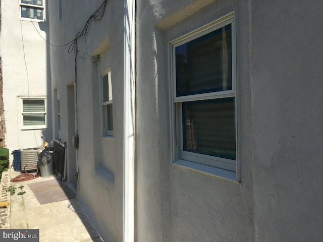 view of property exterior with central air condition unit and stucco siding