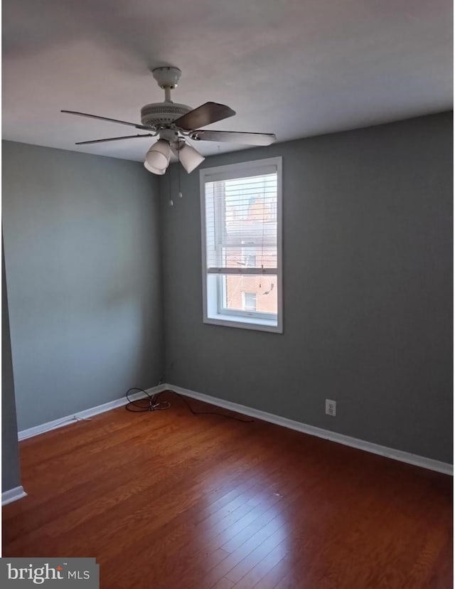 empty room with dark wood-type flooring and ceiling fan