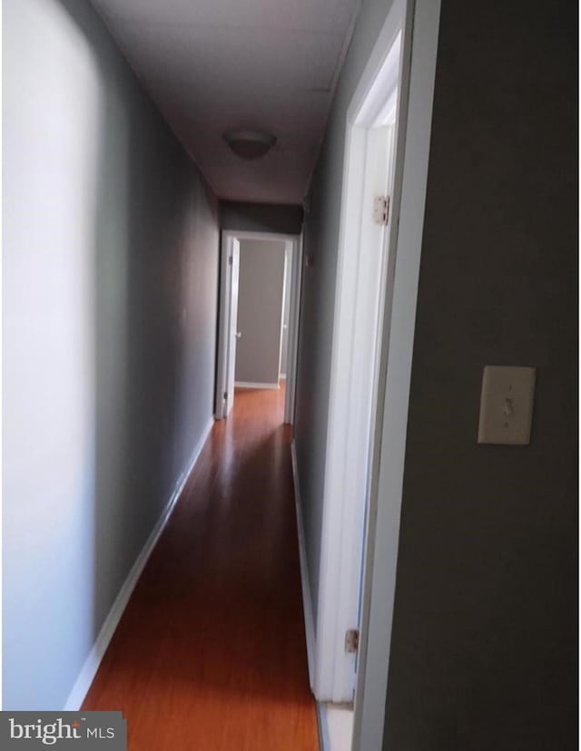 corridor with hardwood / wood-style flooring