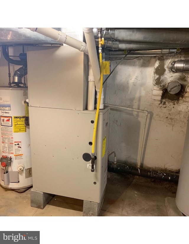 utility room featuring gas water heater and heating unit