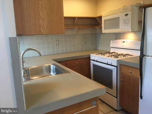 kitchen with a sink, open shelves, tasteful backsplash, white appliances, and light countertops