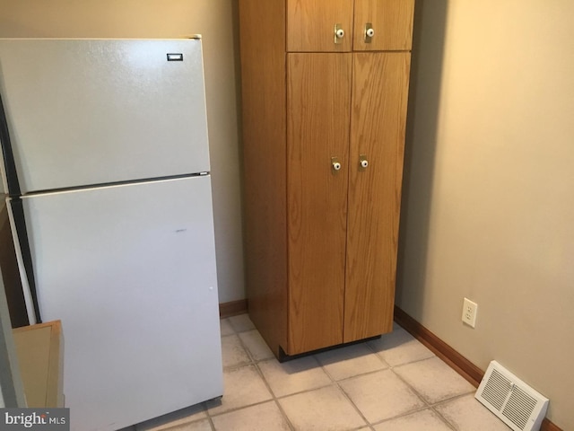 kitchen with white refrigerator and light tile patterned floors