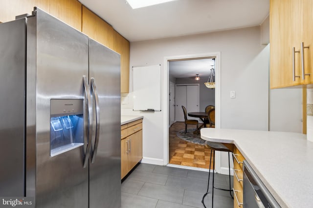 kitchen with stainless steel fridge with ice dispenser and dark tile patterned flooring