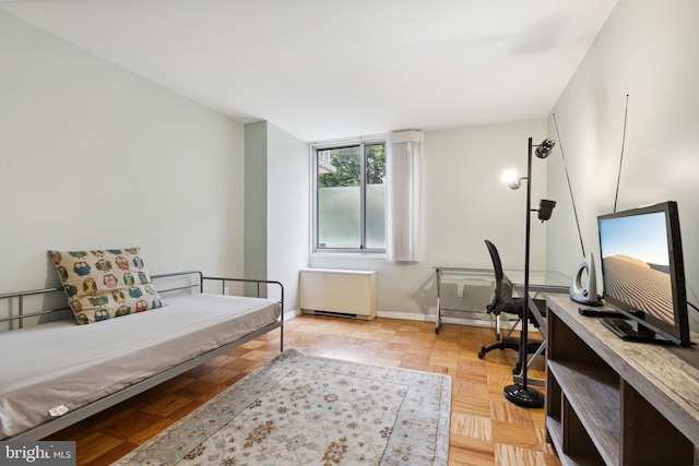 bedroom with light parquet flooring and radiator heating unit