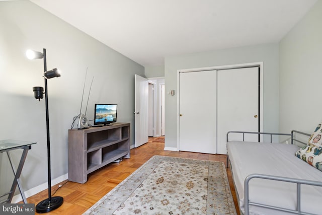 bedroom featuring a closet and light parquet flooring