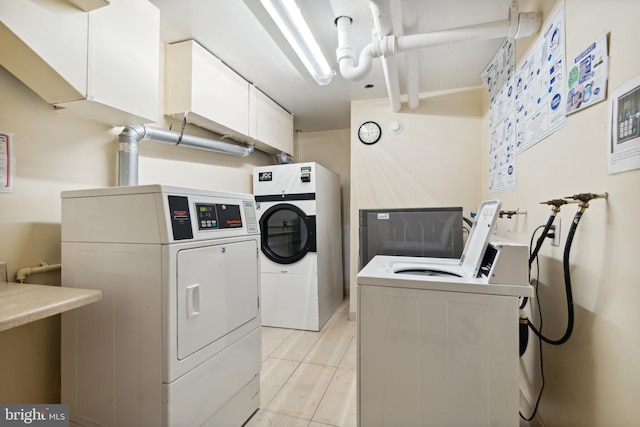 clothes washing area featuring washing machine and clothes dryer and light tile patterned floors