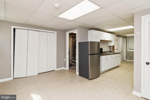 kitchen featuring white cabinetry, a paneled ceiling, and stainless steel refrigerator