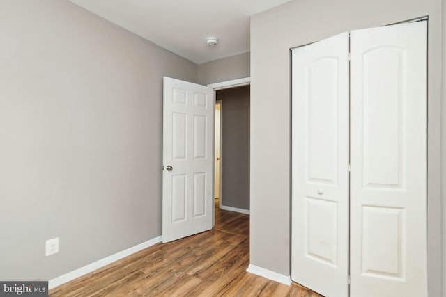 unfurnished bedroom featuring a closet and wood-type flooring