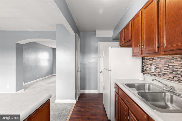 kitchen featuring backsplash, sink, and dark wood-type flooring