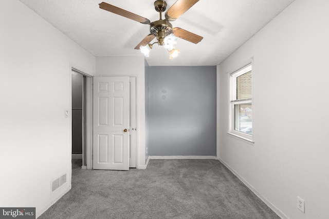 carpeted spare room with ceiling fan