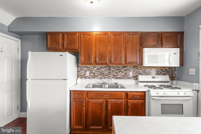 kitchen featuring lofted ceiling, sink, white appliances, wood-type flooring, and decorative backsplash