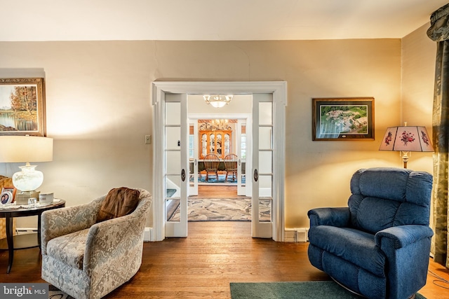 living area featuring wood-type flooring and an inviting chandelier