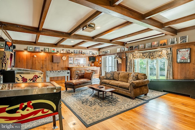 living room featuring light wood-type flooring, beamed ceiling, coffered ceiling, and wooden walls