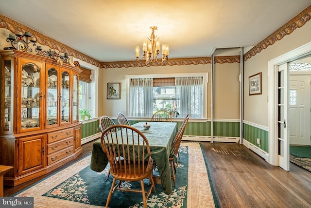 dining area with baseboard heating, dark wood-type flooring, and a chandelier