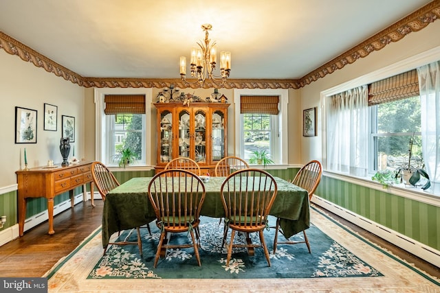 dining room featuring a wealth of natural light, a baseboard radiator, a notable chandelier, and wood-type flooring