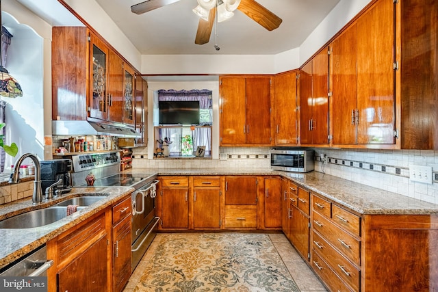 kitchen with appliances with stainless steel finishes, tasteful backsplash, sink, ceiling fan, and light stone counters