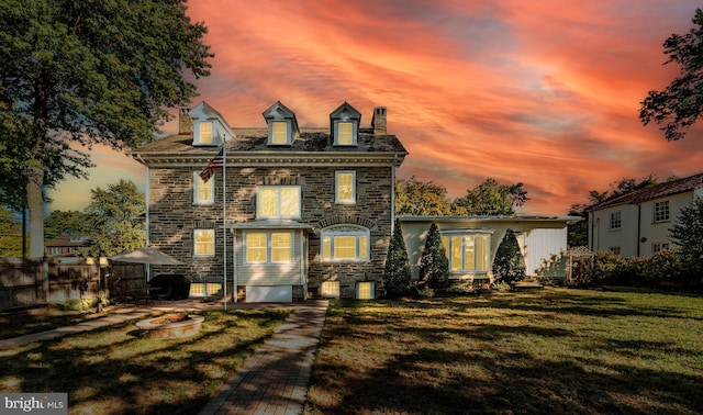 view of front facade featuring a lawn and an outdoor fire pit