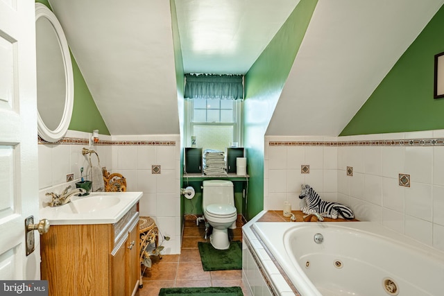 bathroom with tiled tub, vanity, toilet, and tile walls