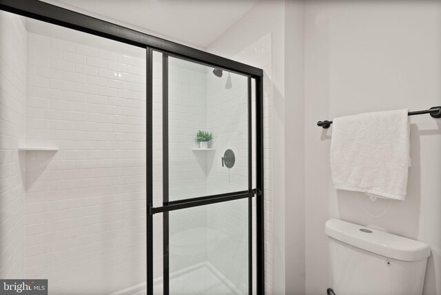 bathroom featuring toilet and an enclosed shower