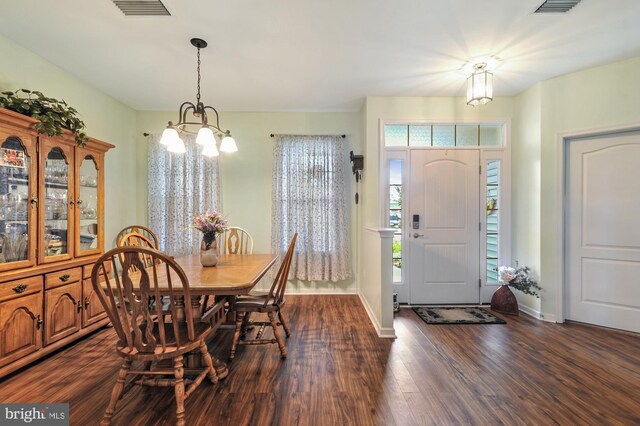 dining room with a notable chandelier and dark wood-type flooring