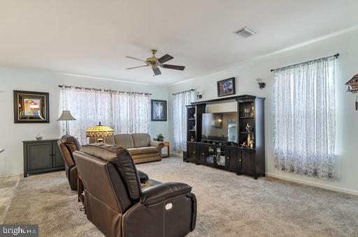 living room with light carpet and ceiling fan