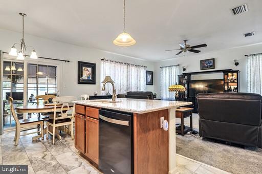 kitchen featuring ceiling fan with notable chandelier, black dishwasher, a kitchen island with sink, and pendant lighting