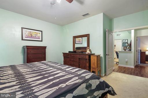 bedroom with light carpet and ceiling fan