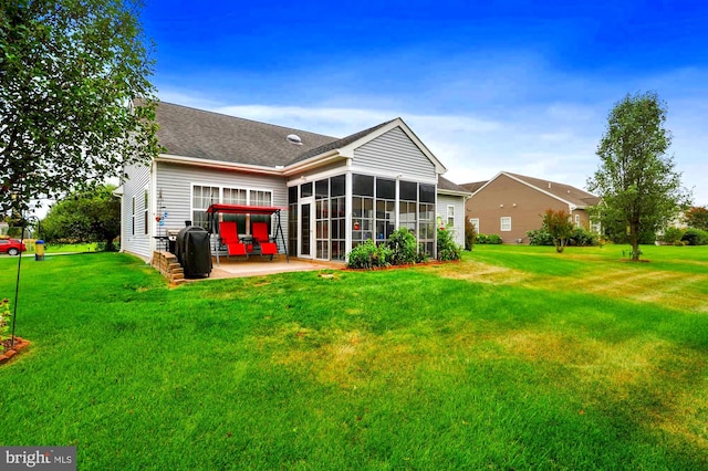 rear view of house with a sunroom, a lawn, and a patio area