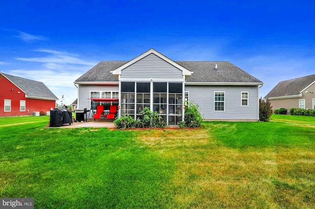 rear view of house with a sunroom, a patio area, central air condition unit, and a lawn