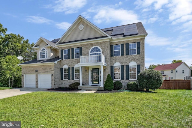 view of front of house with a front lawn, a garage, solar panels, and a balcony