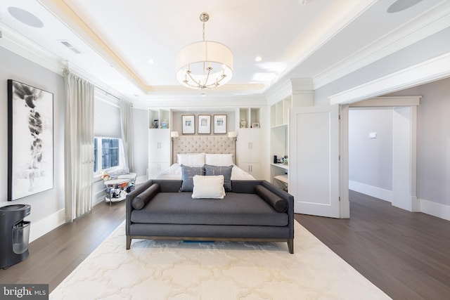 bedroom with a tray ceiling, crown molding, an inviting chandelier, and hardwood / wood-style flooring