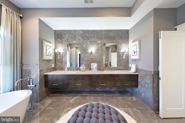 bathroom featuring a tub, vanity, and tile walls