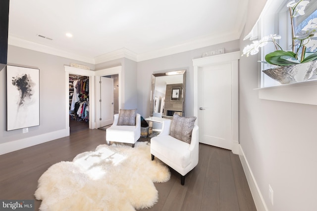 sitting room with crown molding and dark wood-type flooring