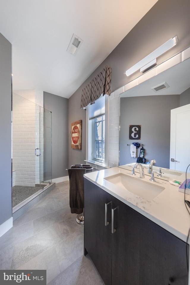 bathroom featuring tile patterned floors, vanity, and a shower with door