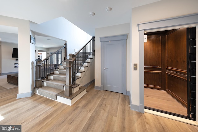 staircase featuring hardwood / wood-style floors and elevator