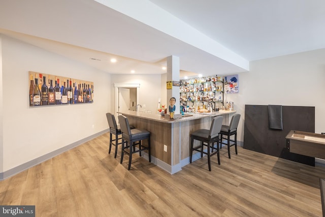 bar with light hardwood / wood-style flooring