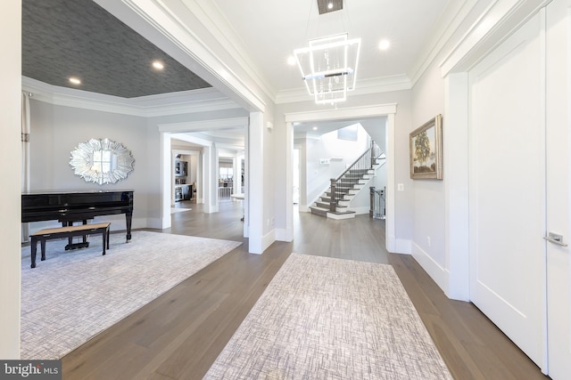 entrance foyer featuring crown molding, hardwood / wood-style floors, and a chandelier