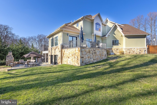 rear view of property with a gazebo, a fireplace, a yard, and a patio