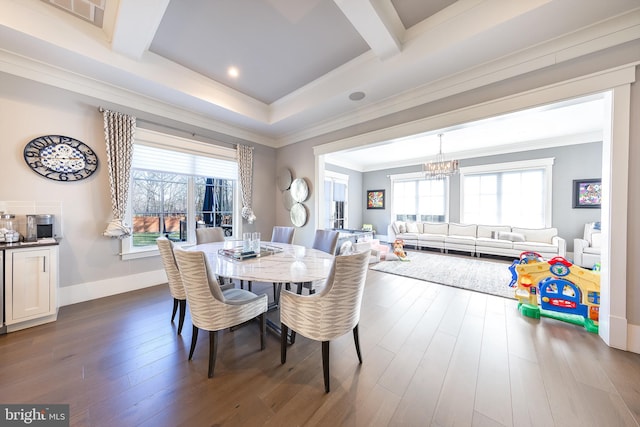 dining area with dark hardwood / wood-style flooring, crown molding, and an inviting chandelier